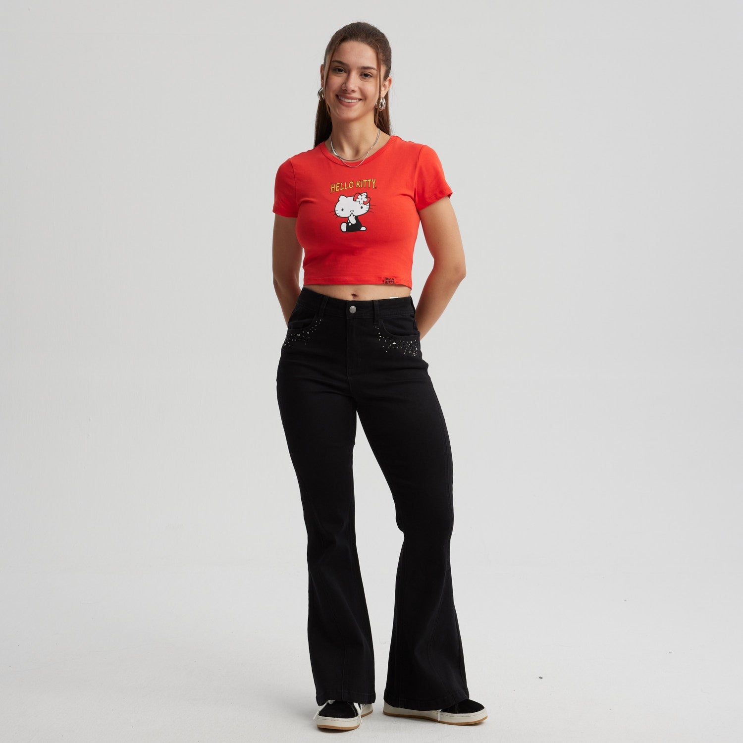 Polera roja de algodón con un diseño de Hello Kitty en estilo cartoon, destacando su lazo rojo y la frase 'HELLO KITTY', ideal para fans del universo Sanrio.