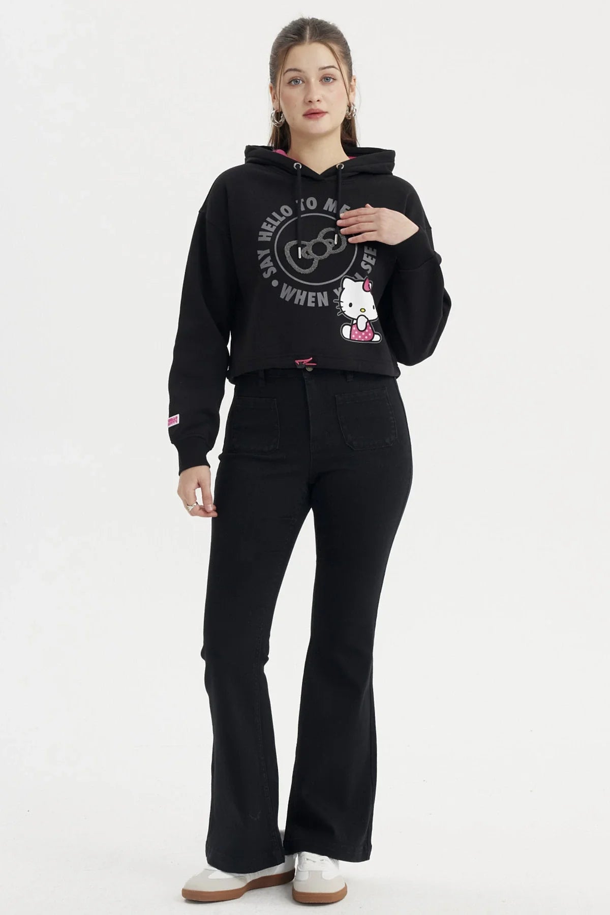 Polerón negro de Hello Kitty con diseño de la icónica gata en pose tierna y texto en gris que dice 'Say hello to me when you see my'.