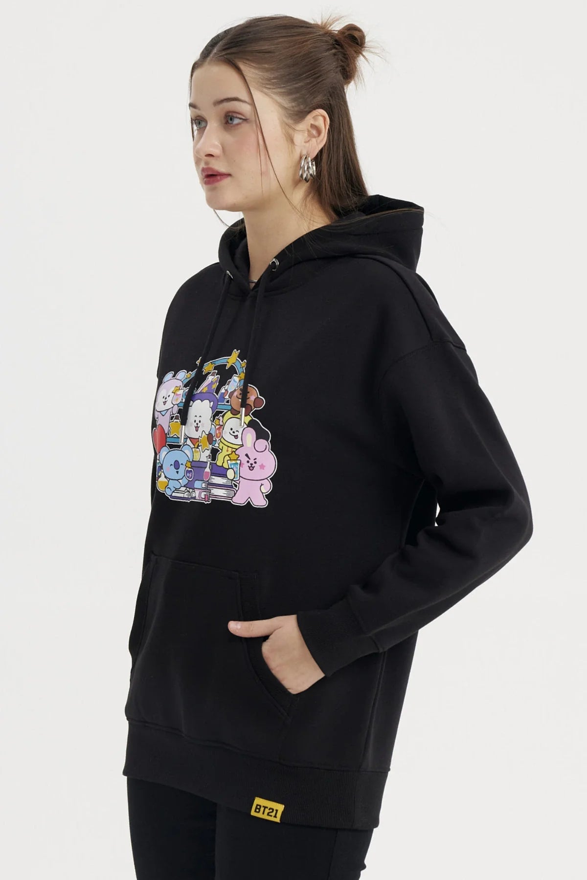 Polerón negro con un vibrante estampado de los personajes de BT21 en colores pastel, mostrando a cada uno en una divertida pose, ideal para fans de BTS.