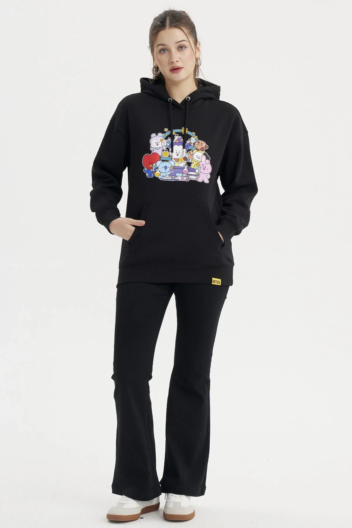 Polerón negro con un vibrante estampado de los personajes de BT21 en colores pastel, mostrando a cada uno en una divertida pose, ideal para fans de BTS.