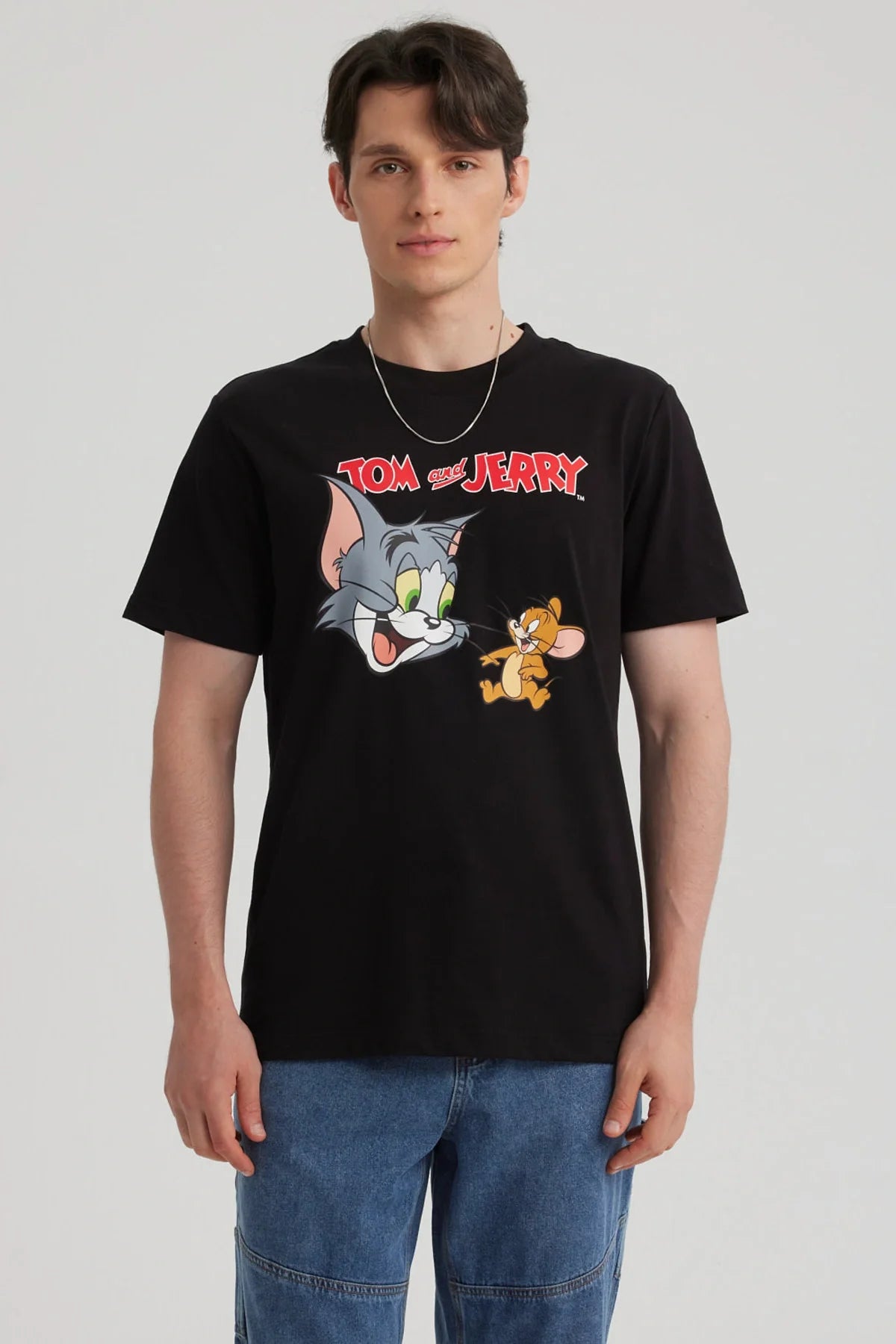 Polera negra de algodón con estampado de Tom y Jerry en estilo cartoon, mostrando a Tom con su icónica expresión y a Jerry en una pose traviesa, perfecta para fans de la clásica serie.