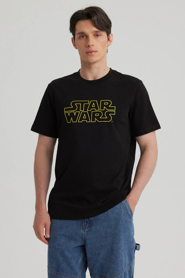 Polera negra de algodón con el icónico logo amarillo de Star Wars en el centro, perfecta para los fanáticos de la saga galáctica.