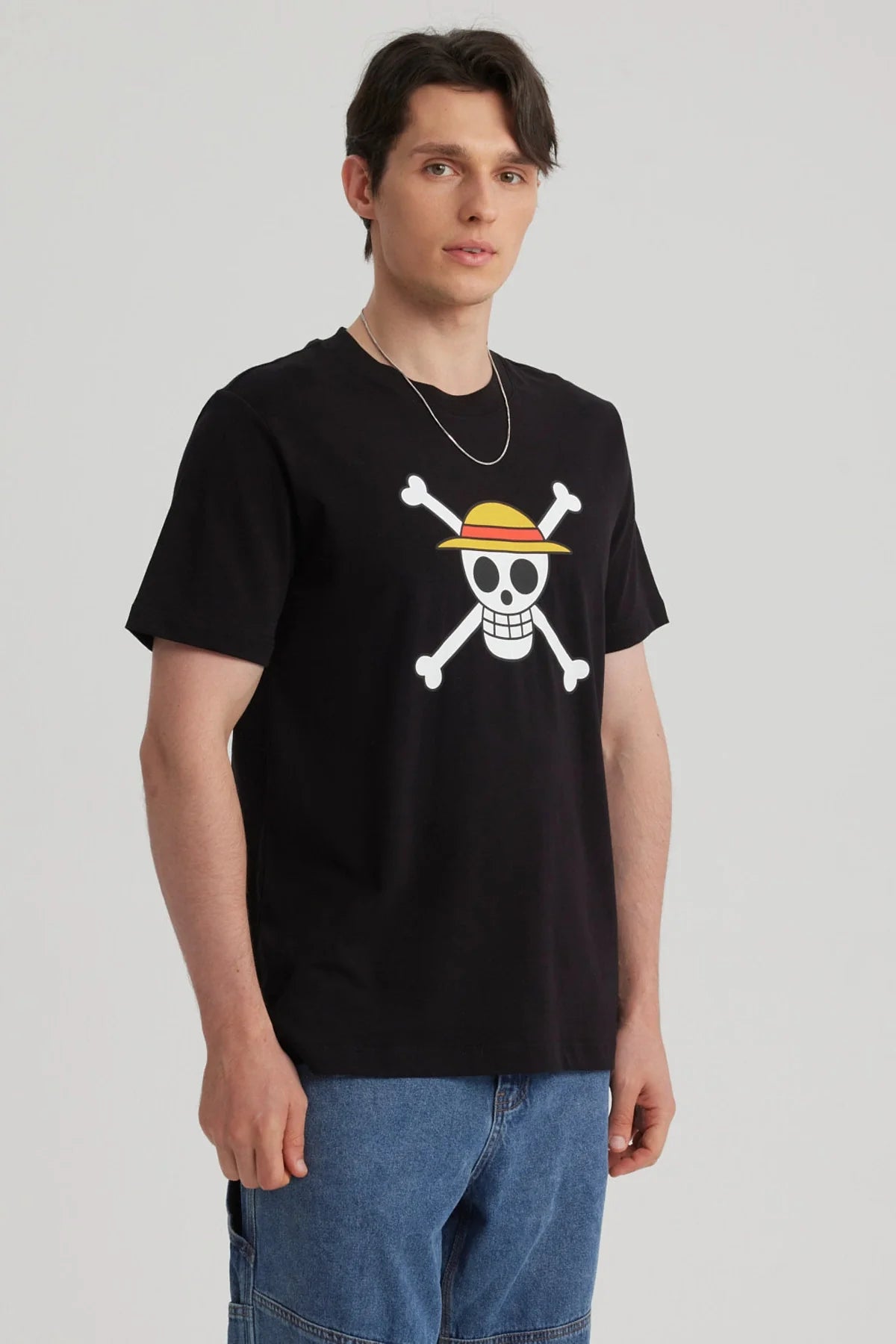 Polera negra de algodón con el icónico logo de los Piratas de Sombrero de Paja de One Piece, destacando la calavera sonriente con sombrero y huesos cruzados.