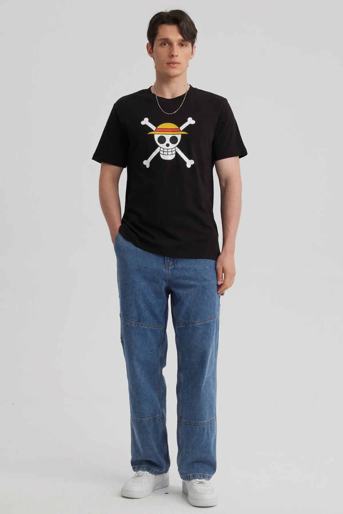 Polera negra de algodón con el icónico logo de los Piratas de Sombrero de Paja de One Piece, destacando la calavera sonriente con sombrero y huesos cruzados.