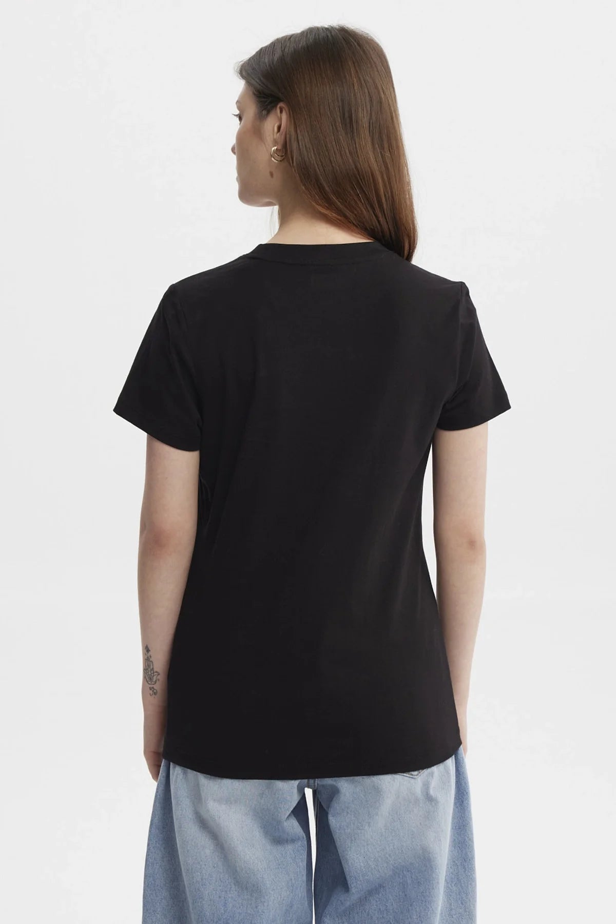 Polera negra con estampado de los personajes de BT21, destacando a Chimmy, Koya, Tata y más en un diseño colorido y divertido, ideal para fans del universo BTS.