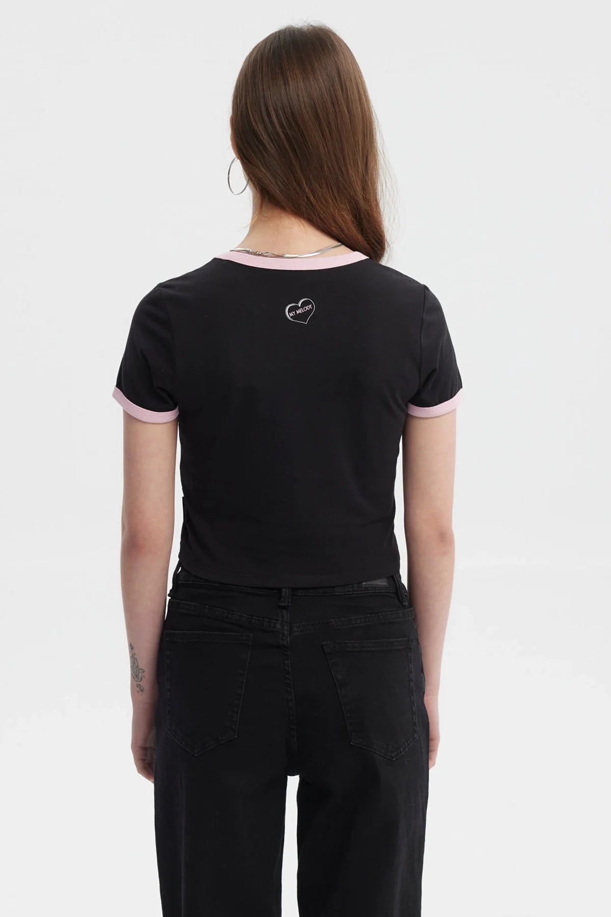 Polera crop negra con ribete rosa que presenta a My Melody sosteniendo un batido, destacando su ternura con la frase 'So Cute' en un diseño vibrante.