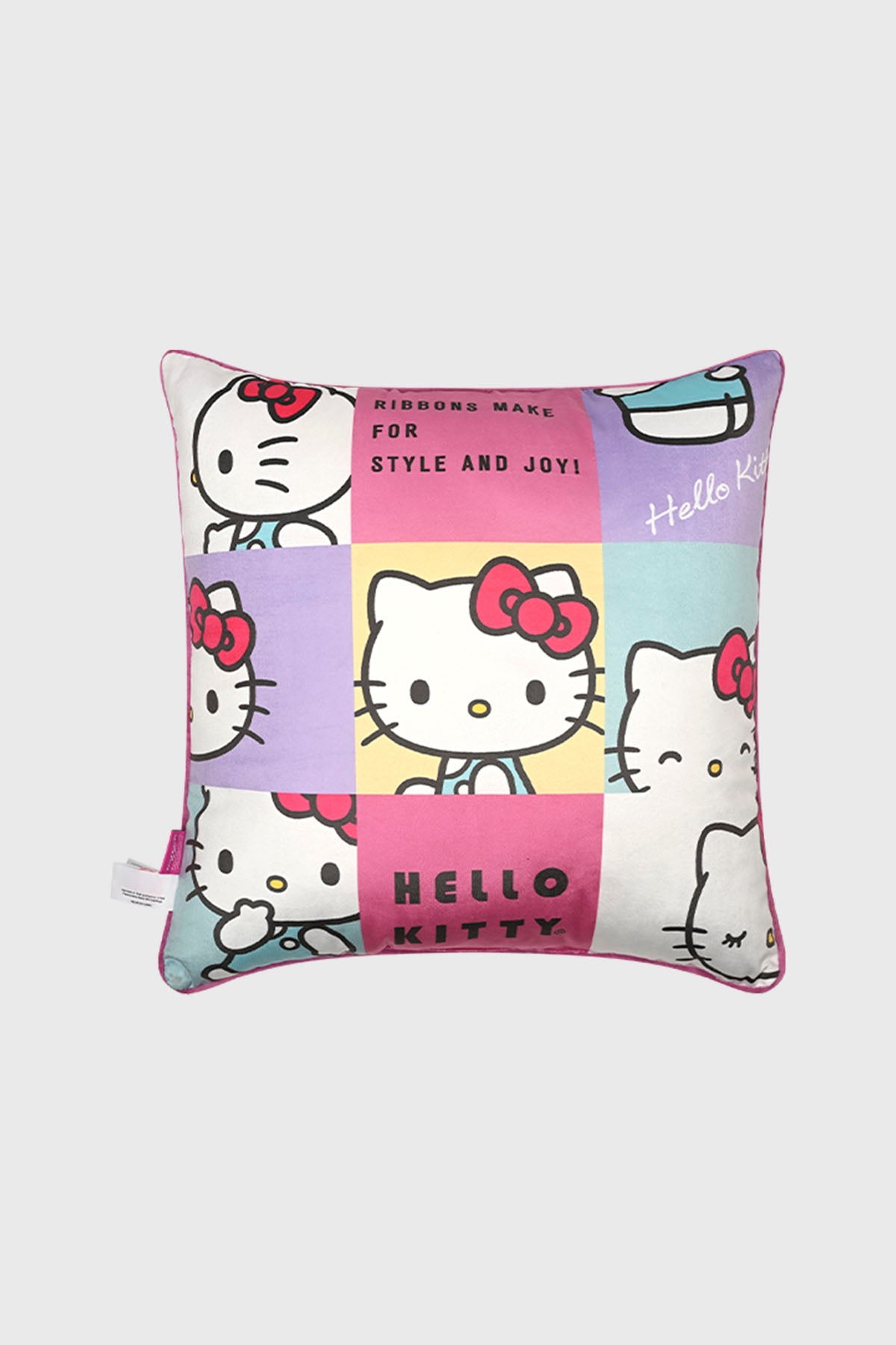 Cojín rosado de Hello Kitty con estampado de cuadros que muestra diferentes expresiones del personaje, incluyendo el texto 'Ribbons make for style and joy'.