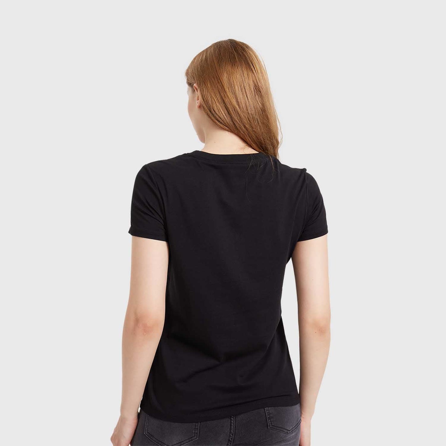 Polera negra de algodón con un diseño vibrante de Daisy Duck en el centro, destacando su icónico moño rosa sobre un fondo de rayas en blanco y negro.
