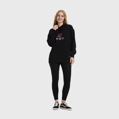 Polerón negro con capucha que presenta un diseño minimalista en tonos rosa y blanco, mostrando el símbolo de Konoha y emblemas de los clanes Uchiha y Hyuga, ideal para fans de Naruto.