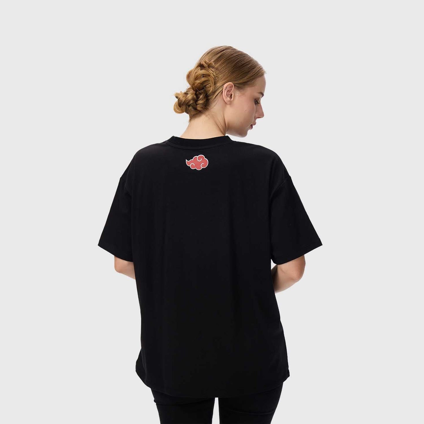 Polera negra de algodón con ilustración de Itachi Uchiha, destacando su icónico vestuario y expresión, acompañada de texto en rojo y blanco.