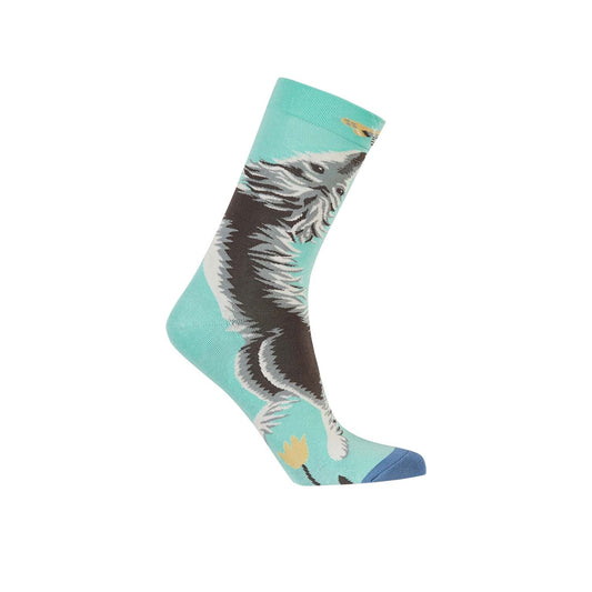 Calcetín de vestir verde con ilustración de un perro saltando, detalles en gris y azul, ideal para amantes de mascotas y estilo divertido.