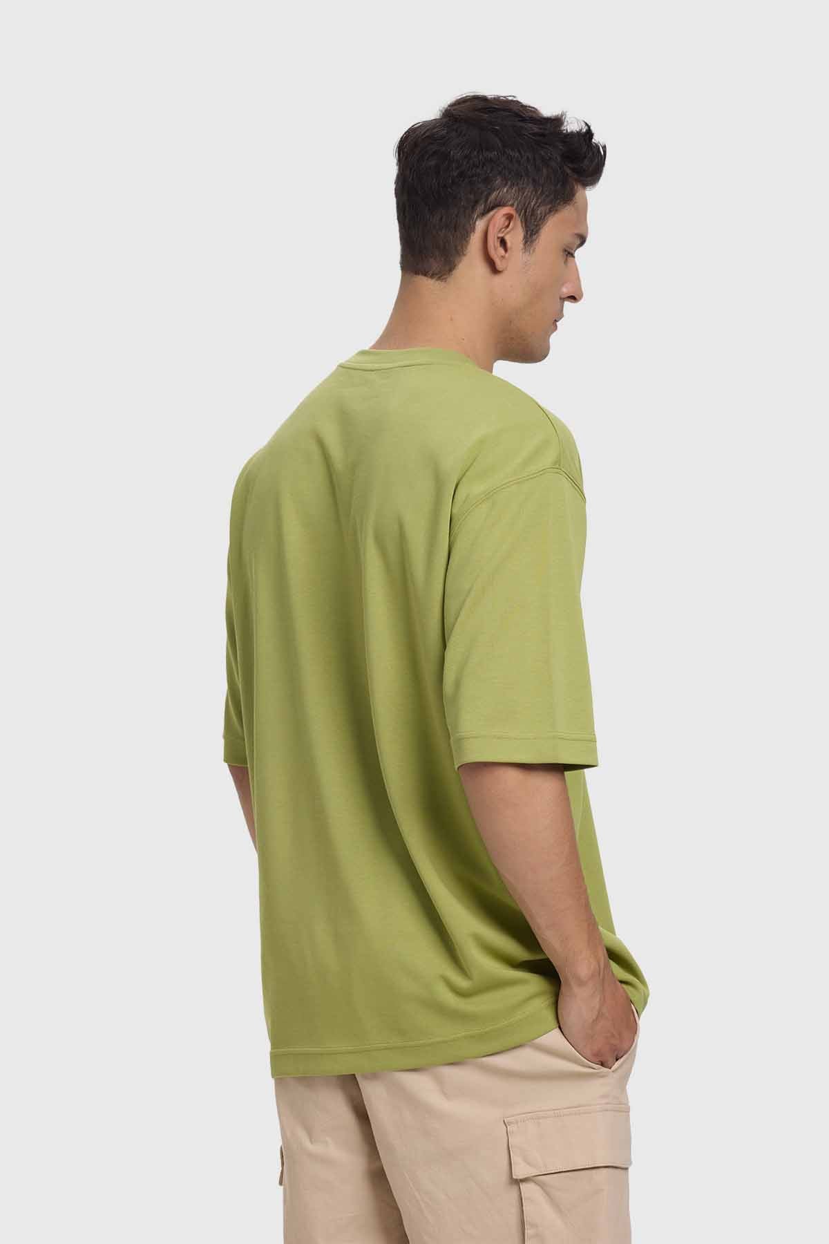 Polera oversize verde de algodón, con un diseño minimalista y logo sutil en el pecho, ideal para los fanáticos de la moda urbana.