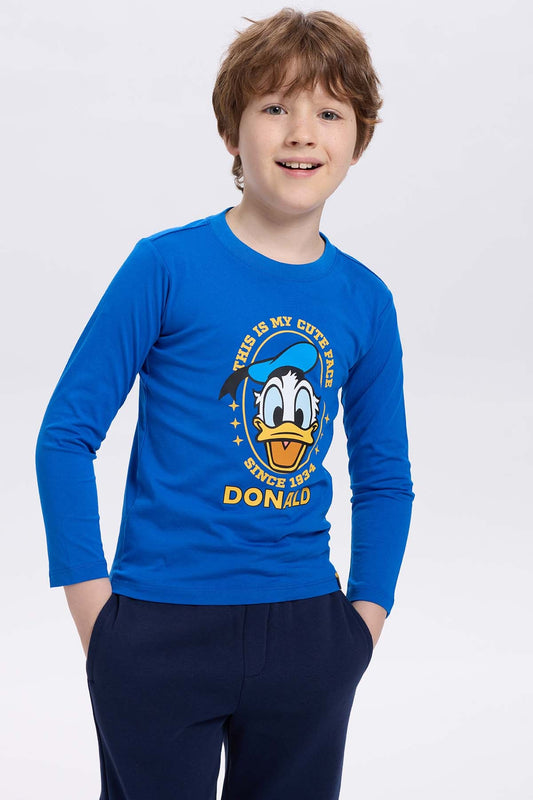 Polera azul con estampado de Pato Donald, diseño gráfico colorido que dice 'THIS IS MY CUTE FACE SINCE 1934' en un estilo divertido y juvenil.
