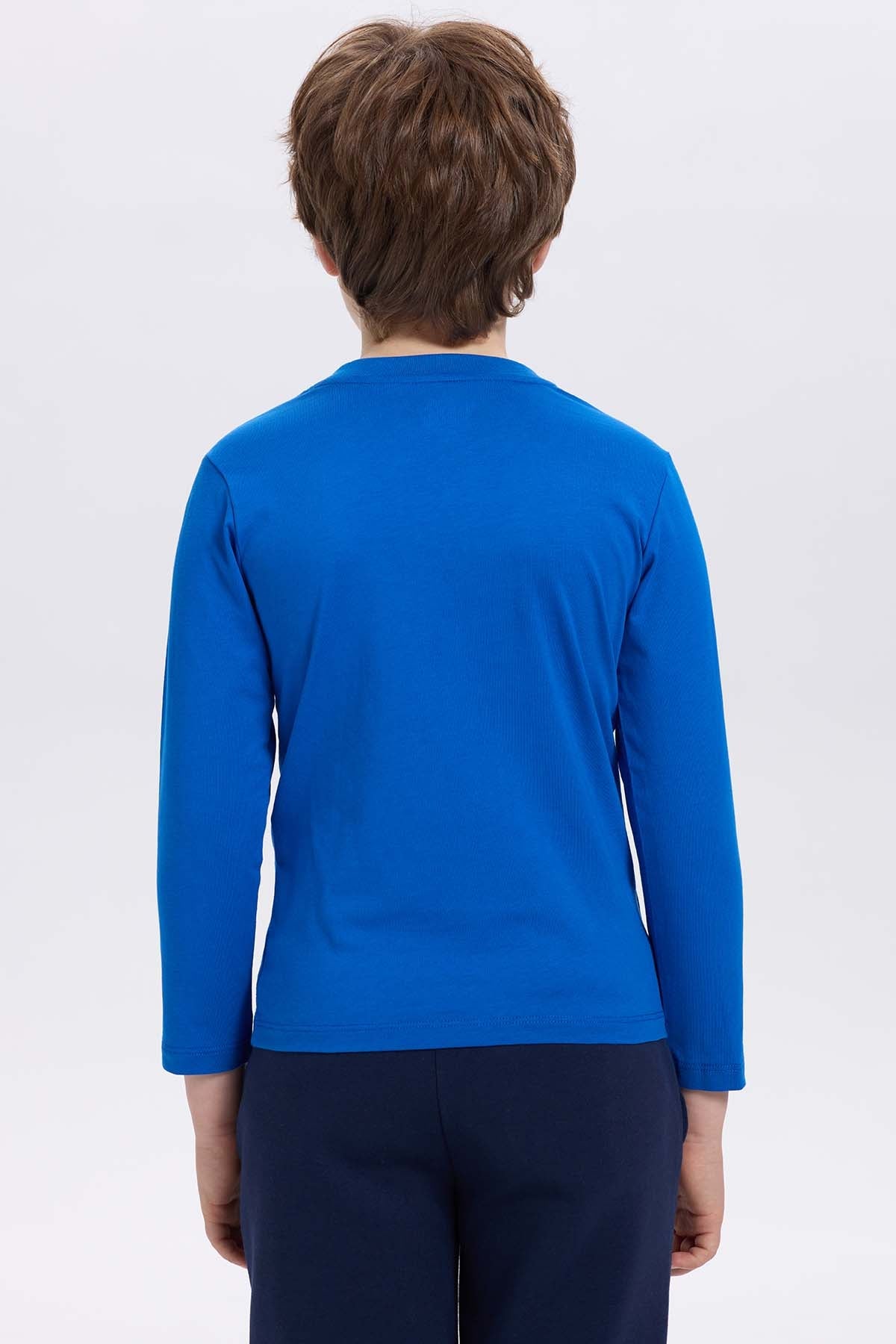 Polera azul con estampado de Pato Donald, diseño gráfico colorido que dice 'THIS IS MY CUTE FACE SINCE 1934' en un estilo divertido y juvenil.