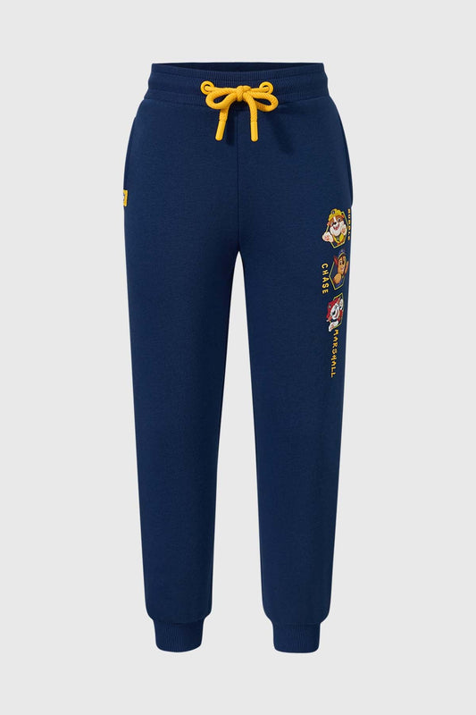 Pantalón buzo azul oscuro con estampado de los personajes de Paw Patrol, incluye a Chase, Marshall y Rubble, con detalles en amarillo y cordón ajustable.
