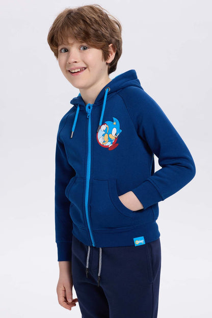 Polerón azul con capucha y detalles en azul celeste, presenta un estampado de Sonic en la parte izquierda, ideal para fans de videojuegos.