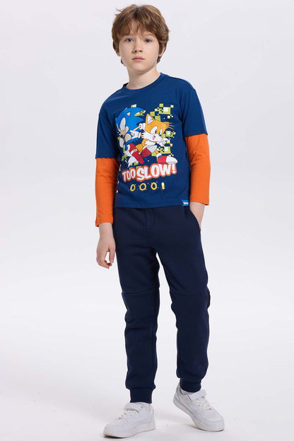 Polera azul con estampado de Sonic y Tails en estilo cartoon, con fondo pixelado y texto 'TOO SLOW!', ideal para fans de Sega.