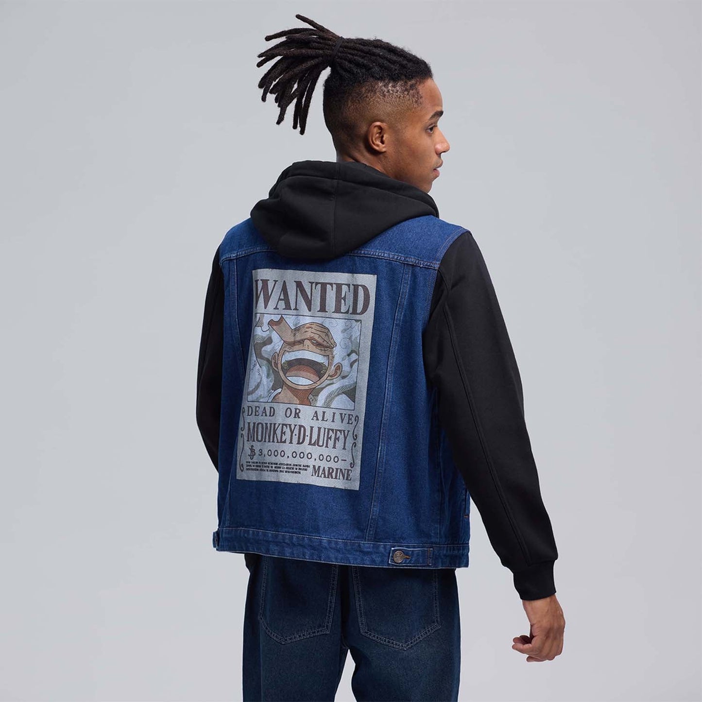 Chaqueta de mezclilla azul con capucha negra, presenta bordados de calavera y uva, evocando la aventura de One Piece y el espíritu pirata.
