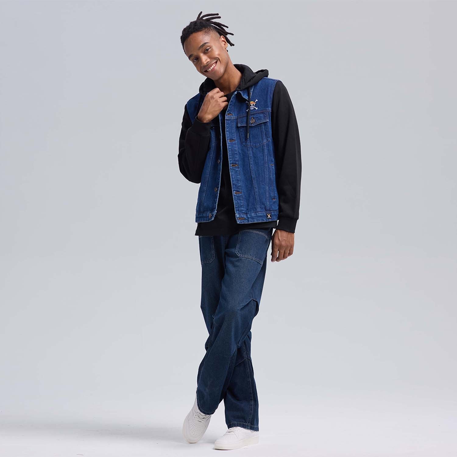 Chaqueta de mezclilla azul con capucha negra, presenta bordados de calavera y uva, evocando la aventura de One Piece y el espíritu pirata.