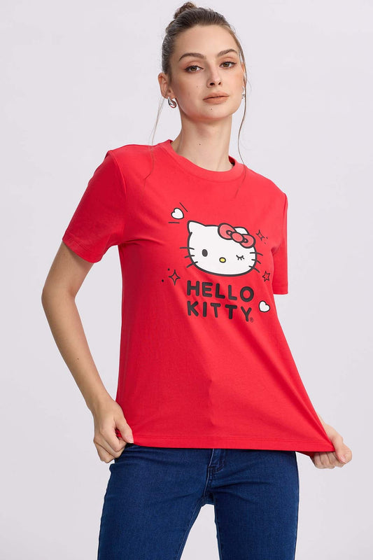 Polera roja de algodón con la icónica cara de Hello Kitty al centro, rodeada de corazones y destellos, perfecta para los fans del universo Sanrio.