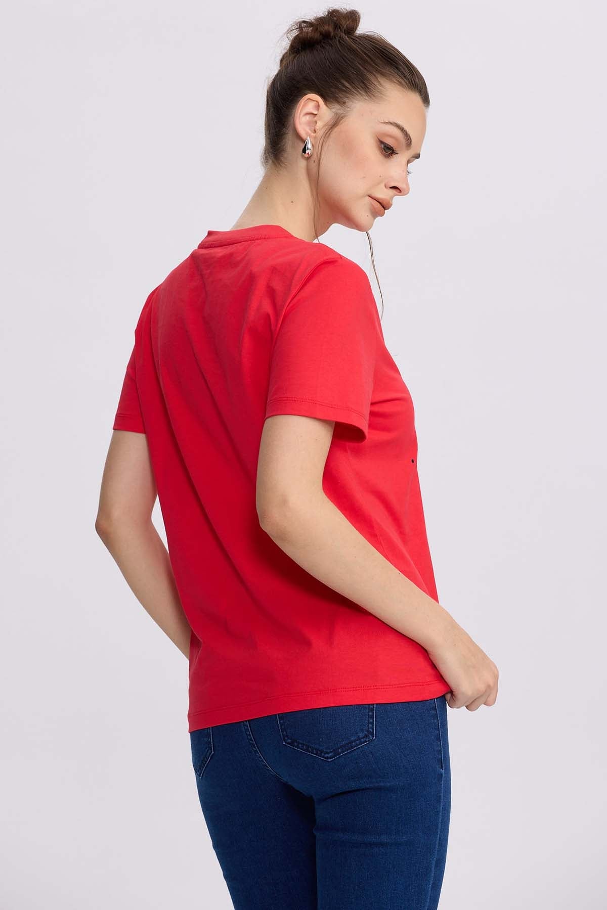Polera roja de algodón con la icónica cara de Hello Kitty al centro, rodeada de corazones y destellos, perfecta para los fans del universo Sanrio.