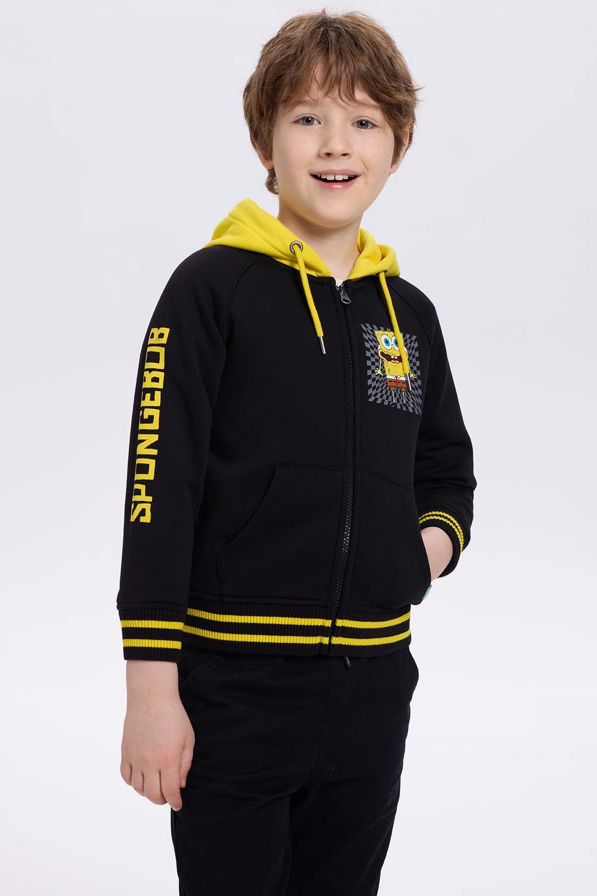 Polerón negro con capucha amarilla, presenta un diseño de Bob Esponja en el pecho y la palabra 'SpongeBob' en la manga, ideal para fans de Nickelodeon.