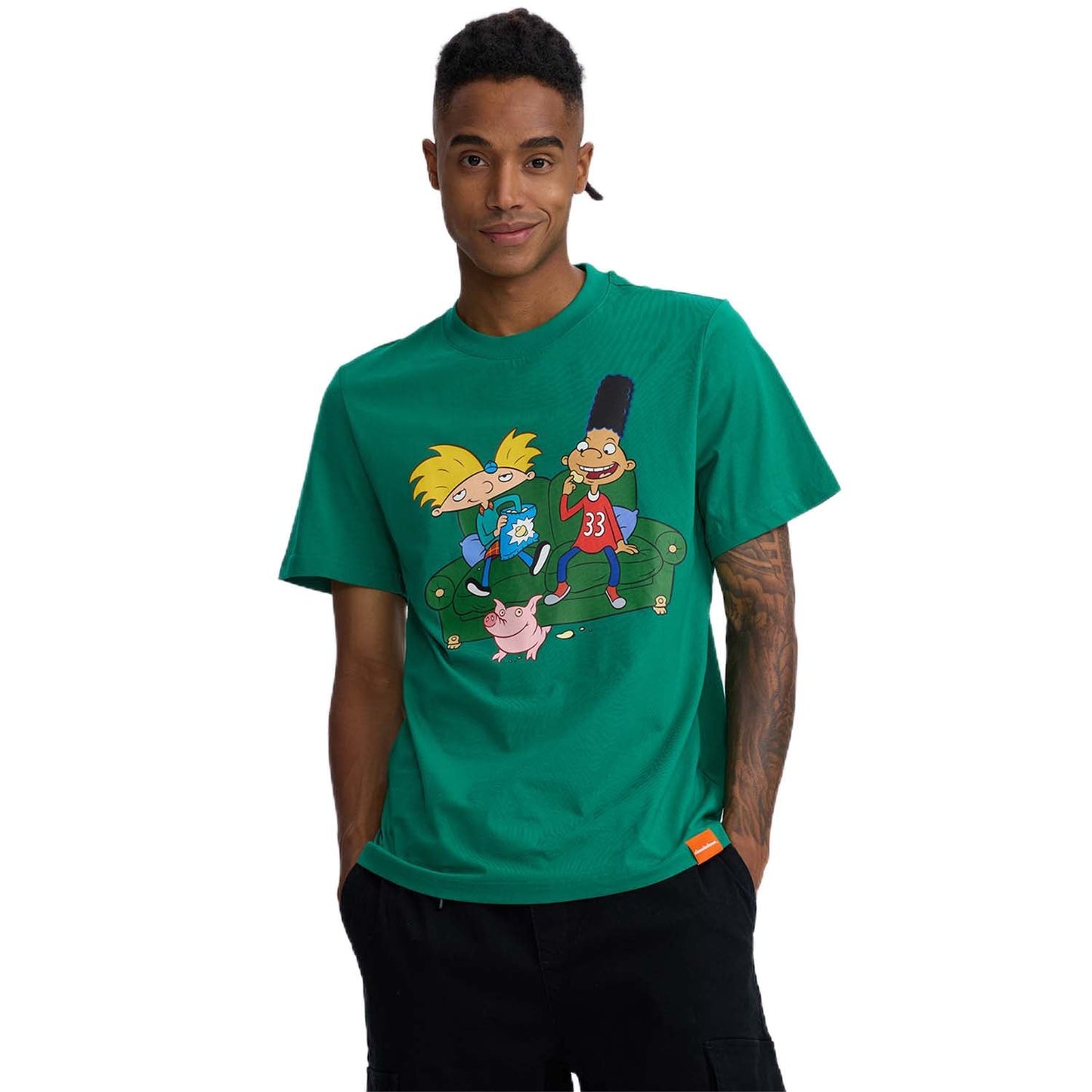 Polera verde de algodón con ilustración de Arnold, Gerald y Helga en un sofá, evocando la nostalgia de 'Hey Arnold' con colores vibrantes y detalles icónicos.