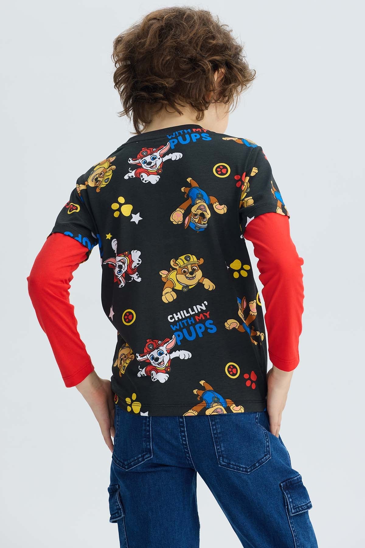 Polera negra de Paw Patrol con estampado colorido de los cachorros en acción y texto divertido, ideal para pequeños fans de la serie.