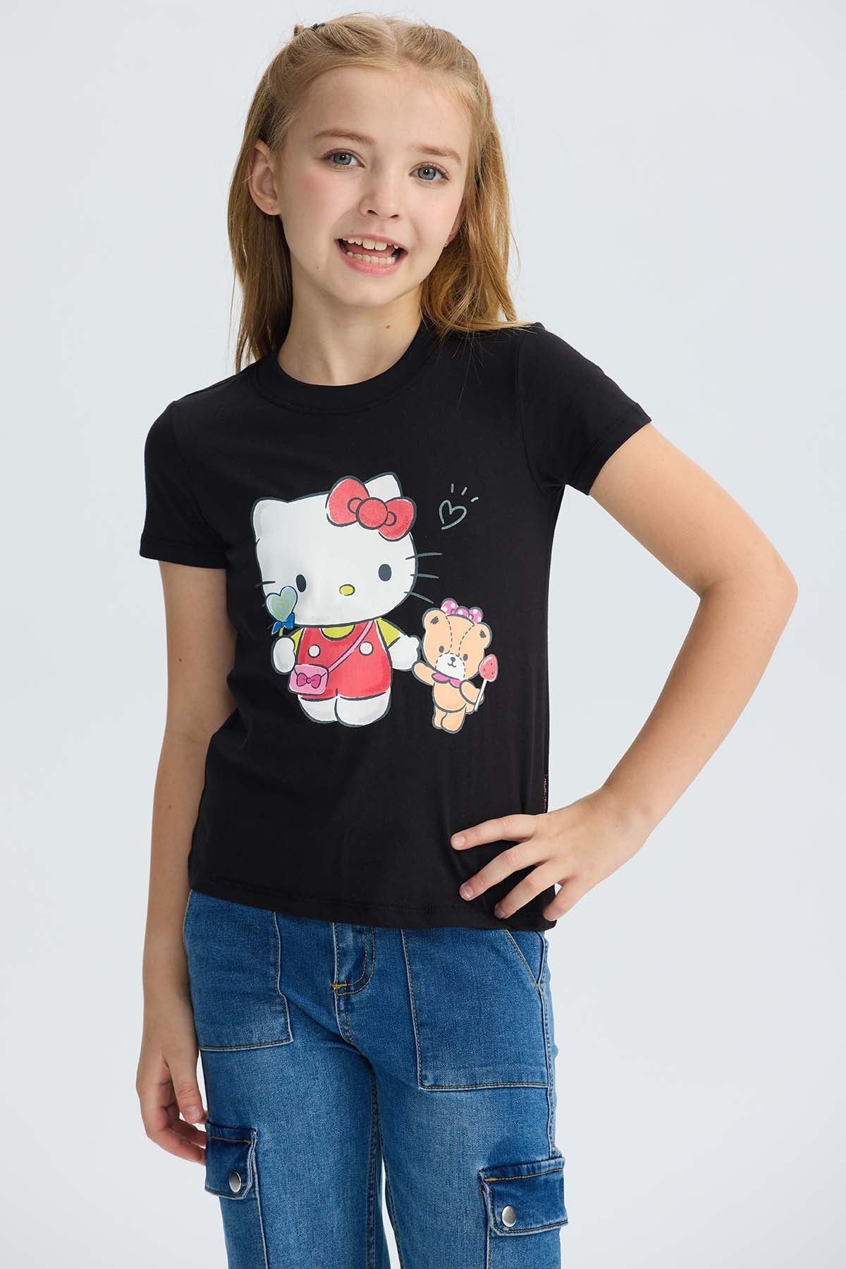 Polera negra de algodón con ilustración de Hello Kitty y su amigo, en estilo colorido y divertido, perfecta para fans de la cultura pop.
