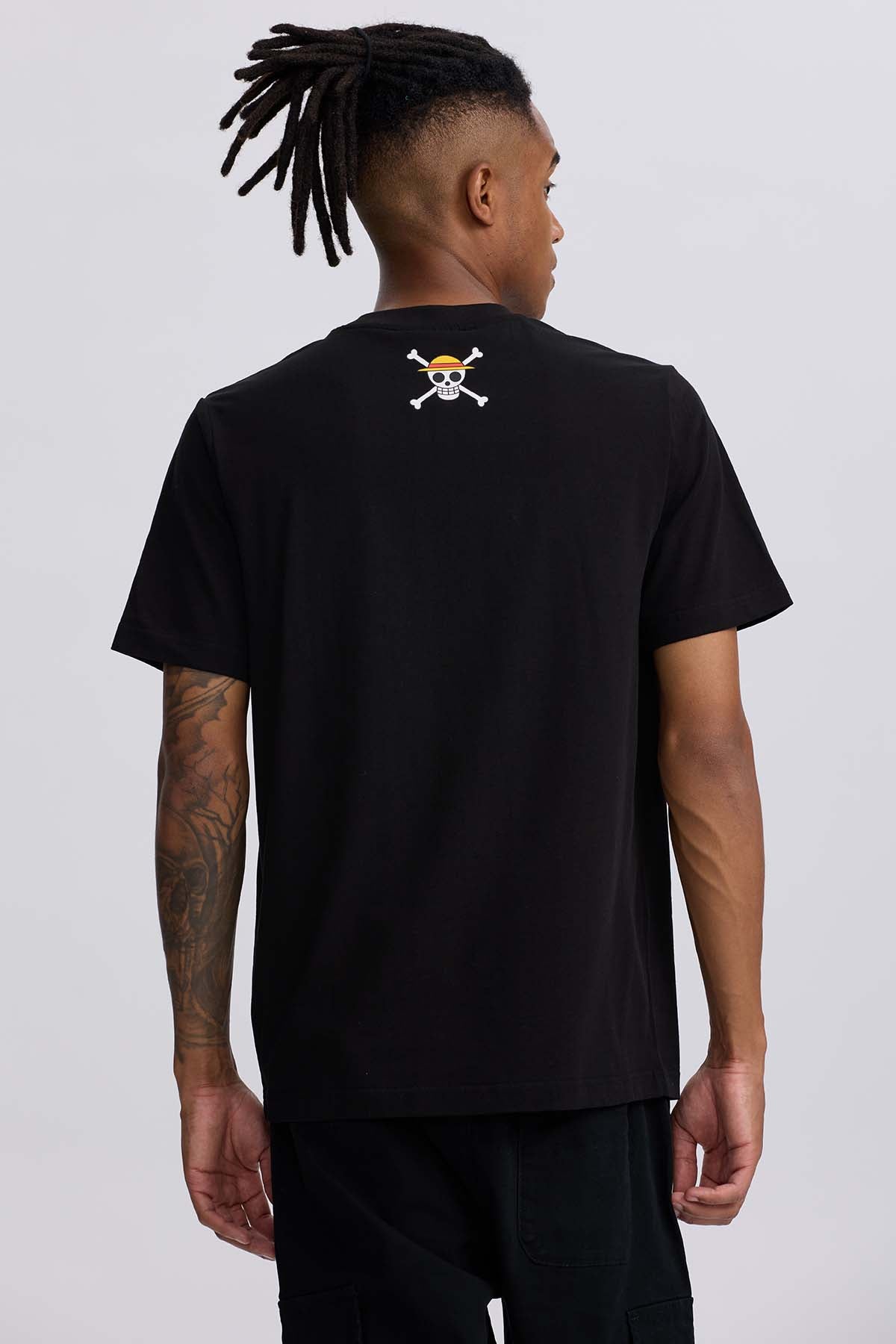 Polera negra de algodón con estampado de Luffy en su forma Gear 4, mostrando puños gigantes y nubes de energía, destacando el título 'One Piece'.