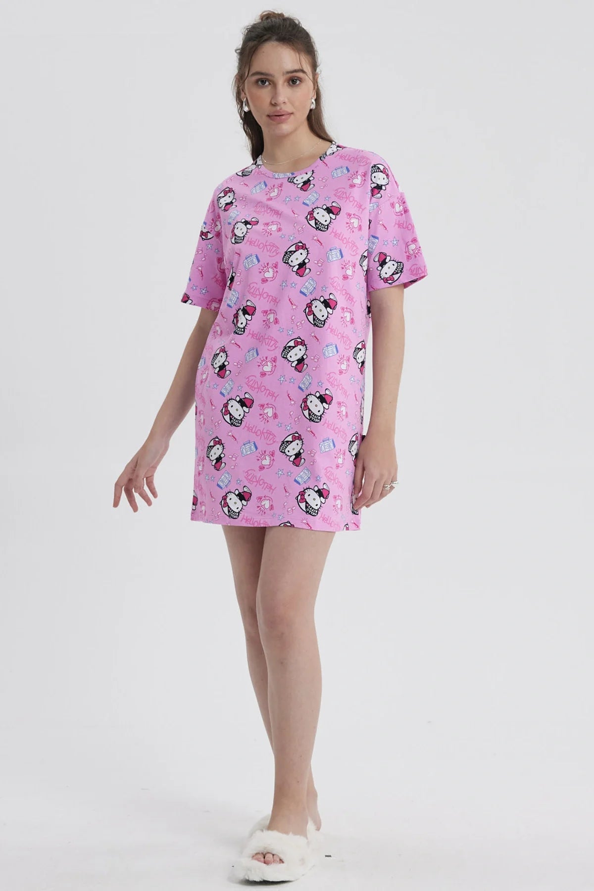 Pijama camisola rosada con estampado de Hello Kitty, presenta ilustraciones divertidas de la icónica gatita en varias poses y elementos de su universo.