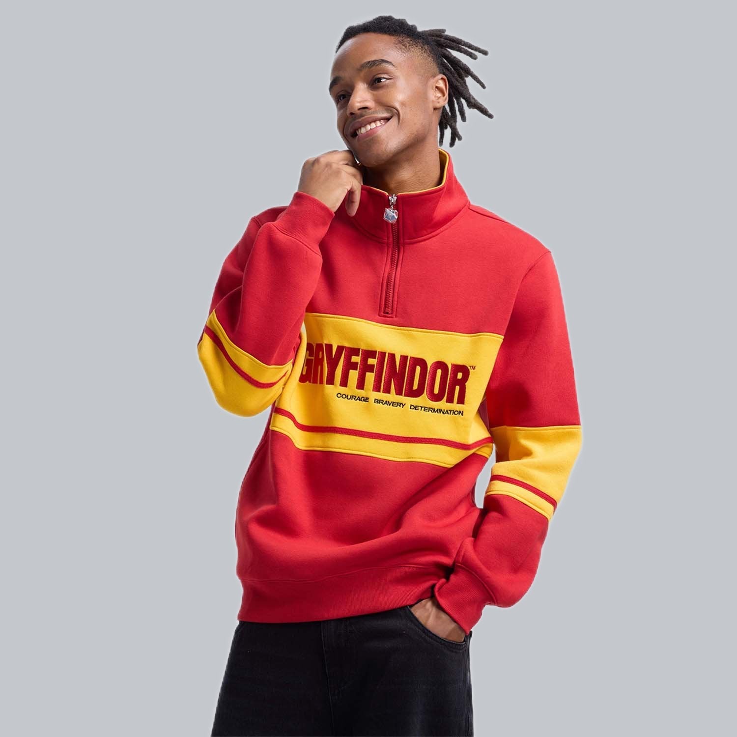 Polerón rojo de Gryffindor con franjas amarillas y el logo en letras grandes, ideal para mostrar tu valentía en el mundo mágico de Harry Potter.