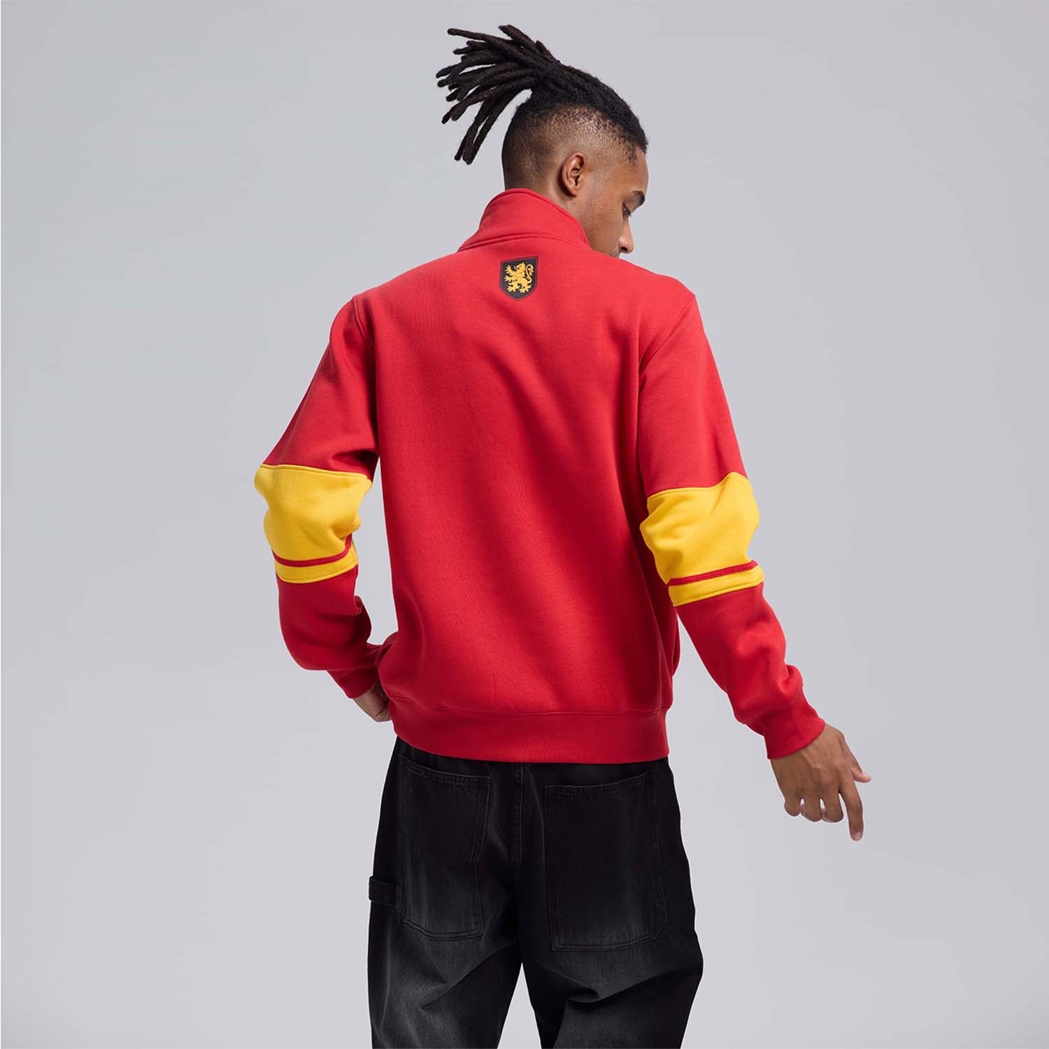 Polerón rojo de Gryffindor con franjas amarillas y el logo en letras grandes, ideal para mostrar tu valentía en el mundo mágico de Harry Potter.