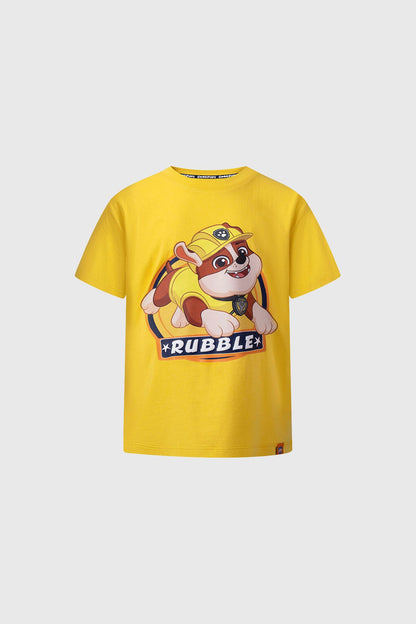Polera amarilla de Paw Patrol con ilustración de Rubble, el bulldog en su traje de construcción, destacando su sonrisa y el logo en la parte inferior.