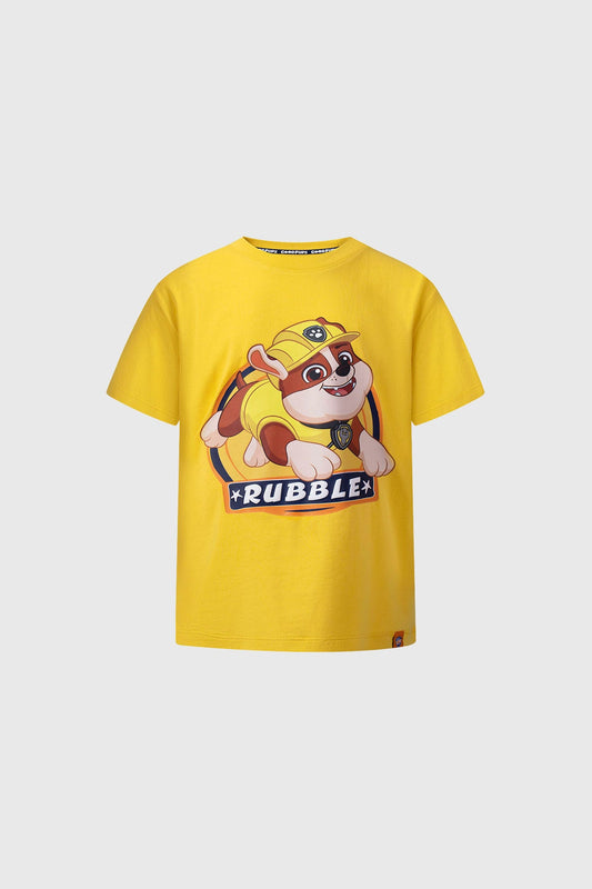 Polera amarilla de Paw Patrol con ilustración de Rubble, el bulldog en su traje de construcción, destacando su sonrisa y el logo en la parte inferior.