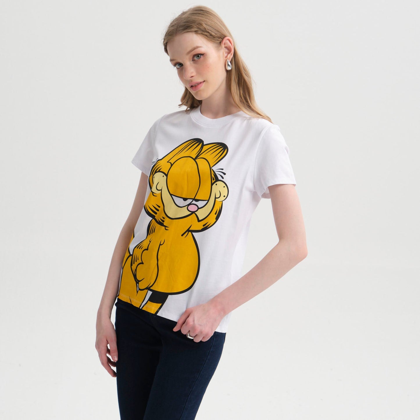 Polera blanca de Garfield con ilustración colorida del icónico gato perezoso en pose relajada, captura la esencia de la tira cómica clásica.