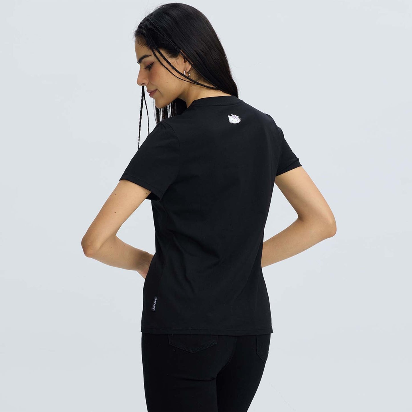 Polera negra de algodón con un diseño de Hello Kitty sosteniendo flores y un lazo rosa, acompañada del texto 'HelloSity' en un estilo divertido.