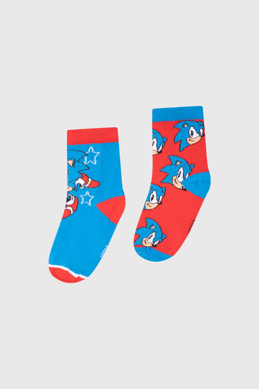 Calcetín bipack en azul y rojo con estampado de Sonic the Hedgehog, mostrando su icónica sonrisa y estrellas, ideal para fans de Sega.