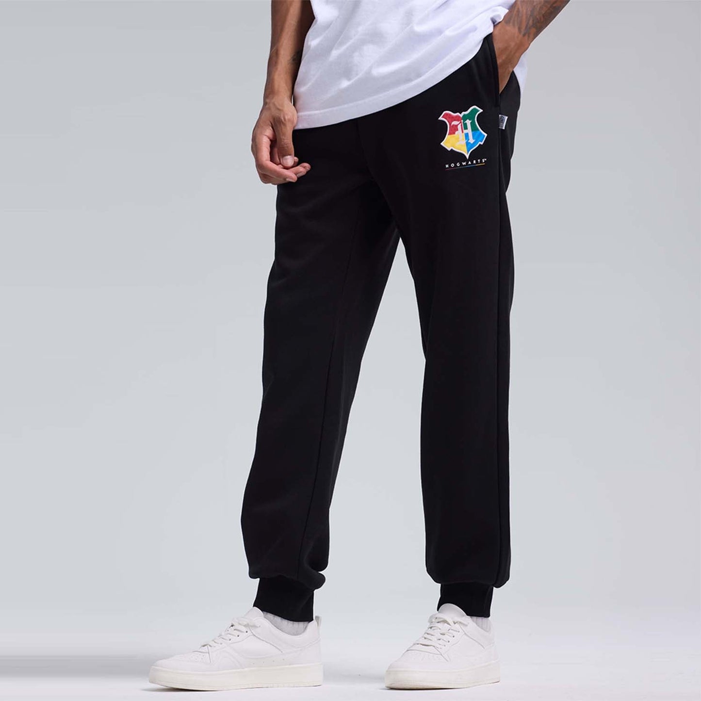 Pantalón buzo negro con el emblema de Hogwarts en colores vibrantes, ideal para fanáticos de Harry Potter que buscan comodidad y estilo.