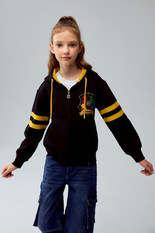 Polerón negro con capucha y detalles en amarillo, presenta el escudo de Hogwarts en el pecho y franjas en las mangas, ideal para los fans de Harry Potter.