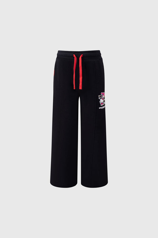 Pantalón buzo negro de Hello Kitty con estampado colorido de la icónica gatita en el lado, con cordones rojos que añaden un toque vibrante.