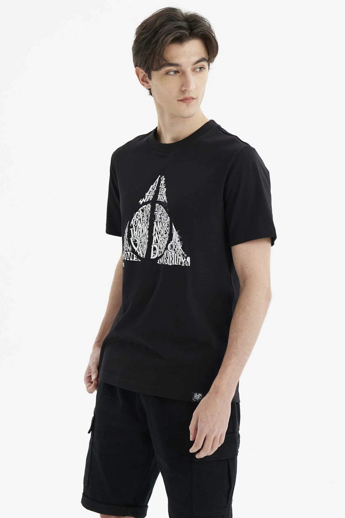 Polera negra de Harry Potter con un diseño en blanco del símbolo de las Reliquias de la Muerte, resaltando palabras icónicas de la saga.