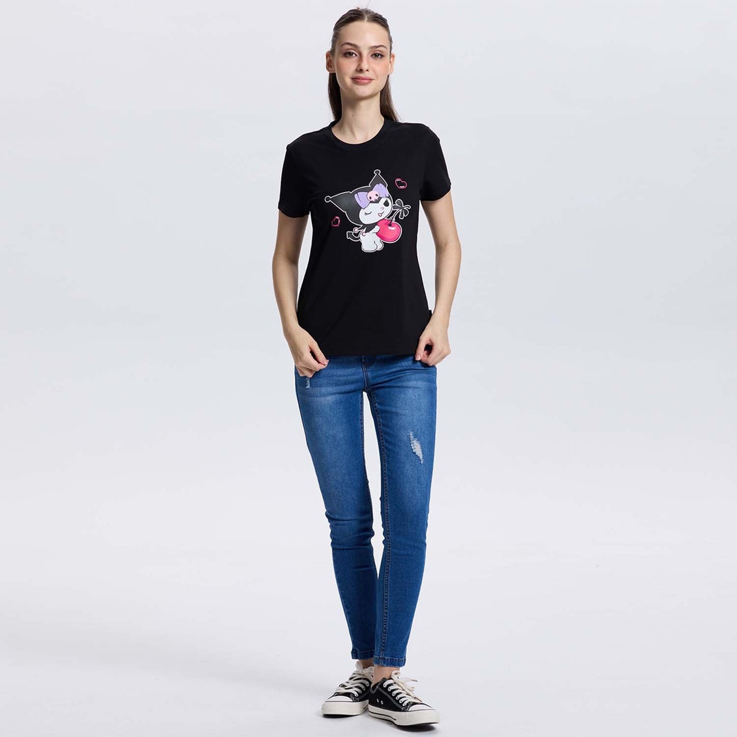 Polera negra de algodón con ilustración de Kuromi sosteniendo un corazón rojo, detalles en rosa y labios en el fondo, ideal para fans de Sanrio.