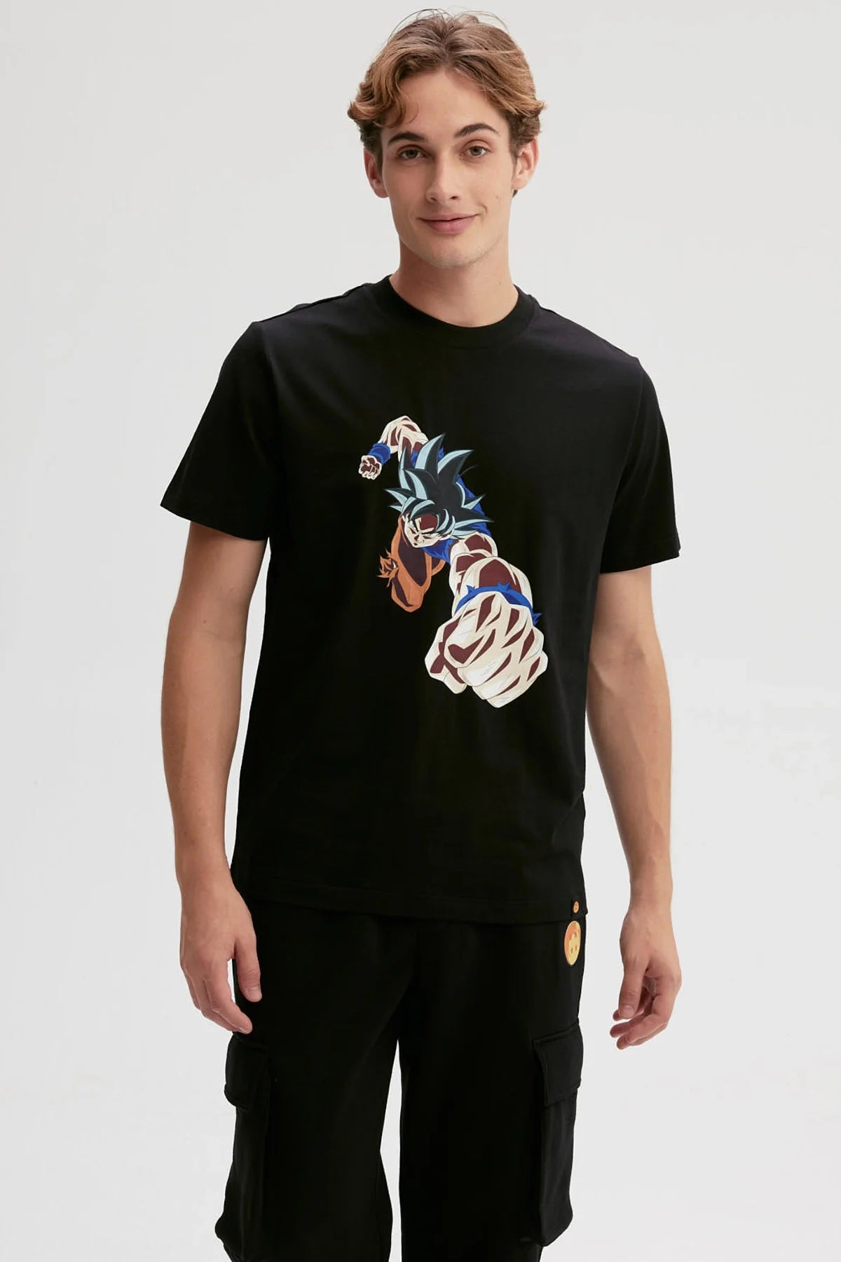 Polera negra de algodón con ilustración de Goku lanzando un puñetazo, estilo anime vibrante y dinámico, captura la esencia de Dragon Ball.