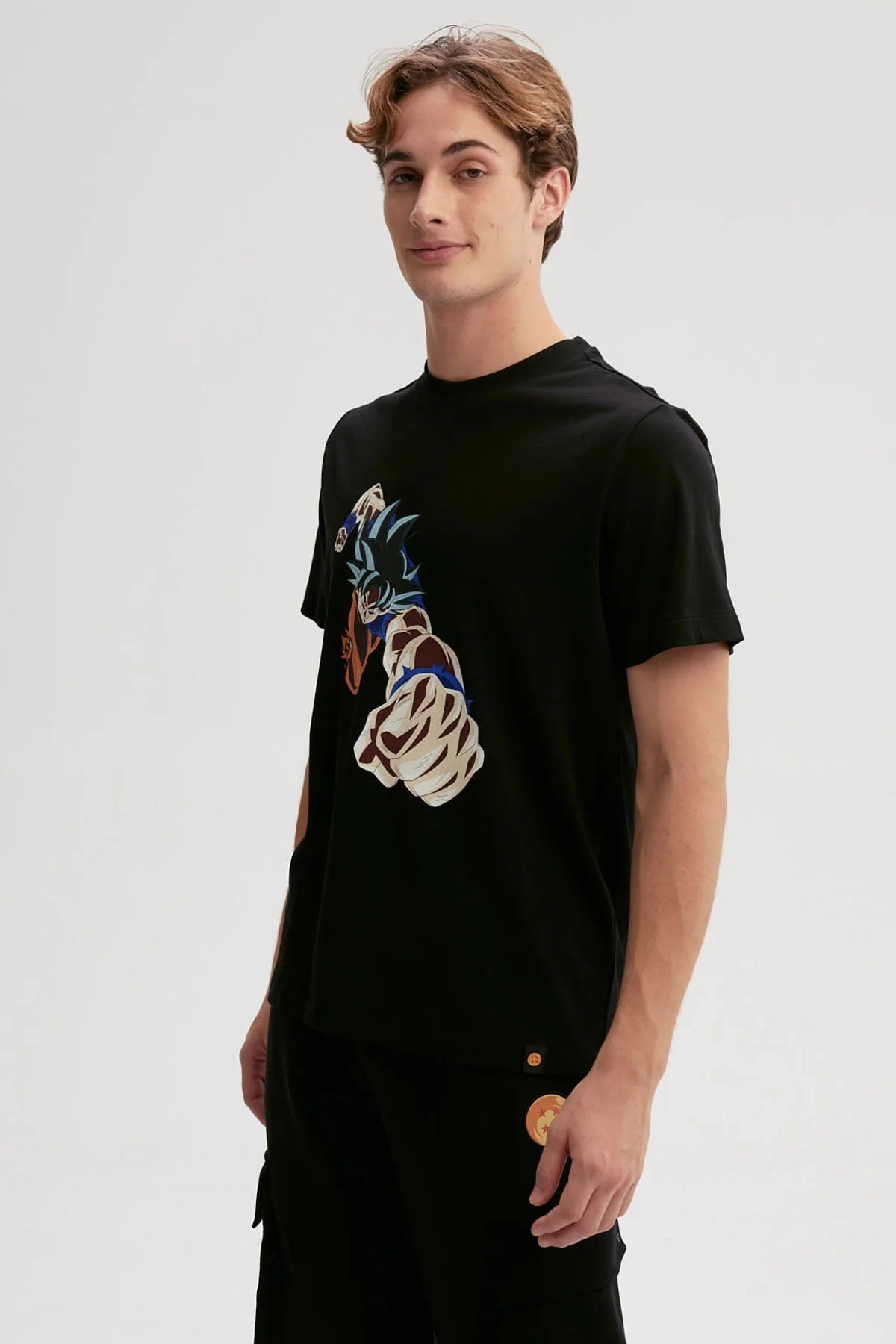 Polera negra de algodón con ilustración de Goku lanzando un puñetazo, estilo anime vibrante y dinámico, captura la esencia de Dragon Ball.