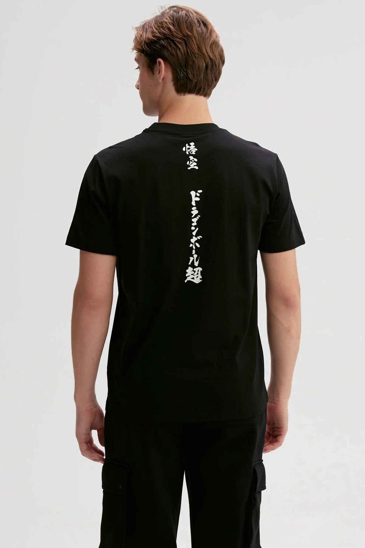 Polera negra de algodón con ilustración de Goku lanzando un puñetazo, estilo anime vibrante y dinámico, captura la esencia de Dragon Ball.