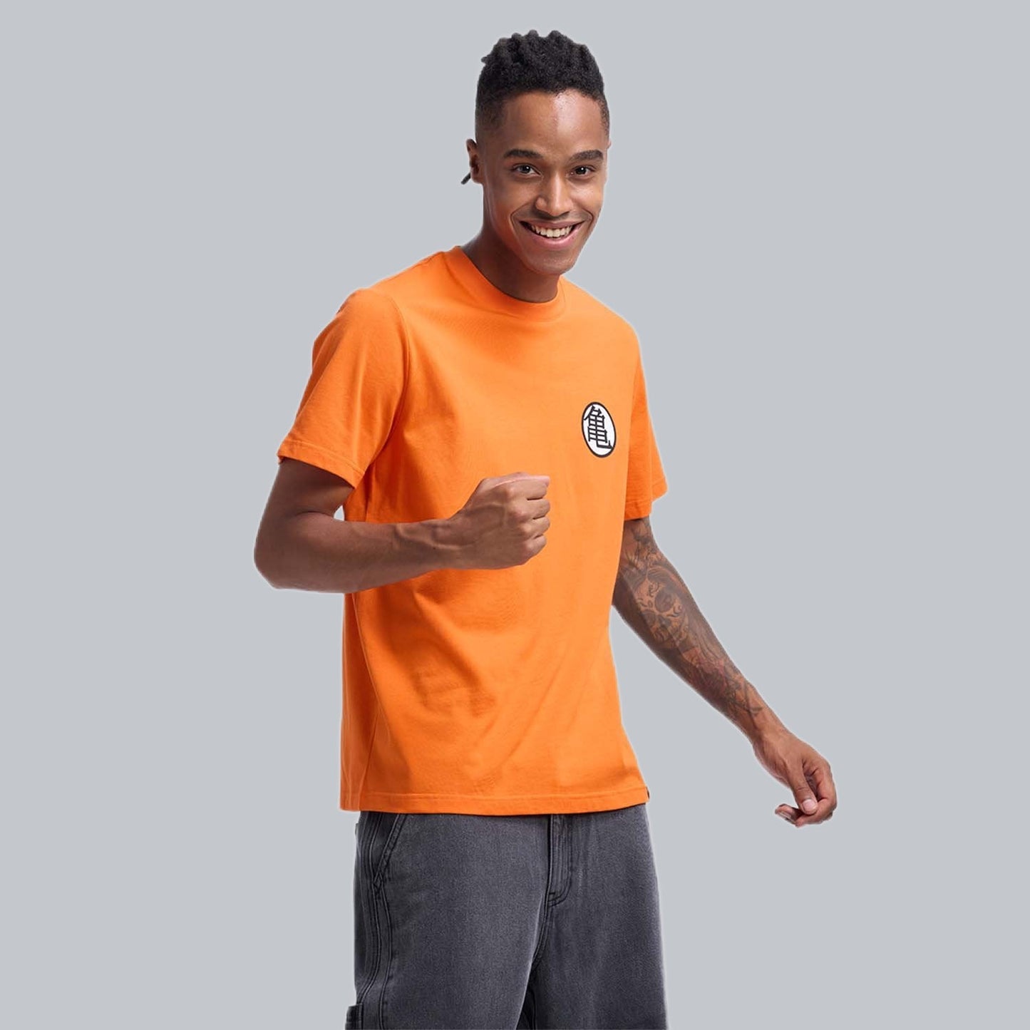 Polera naranja de Dragon Ball con el icónico símbolo de la tortuga en el pecho, confeccionada en 100% algodón, ideal para fans de la saga.