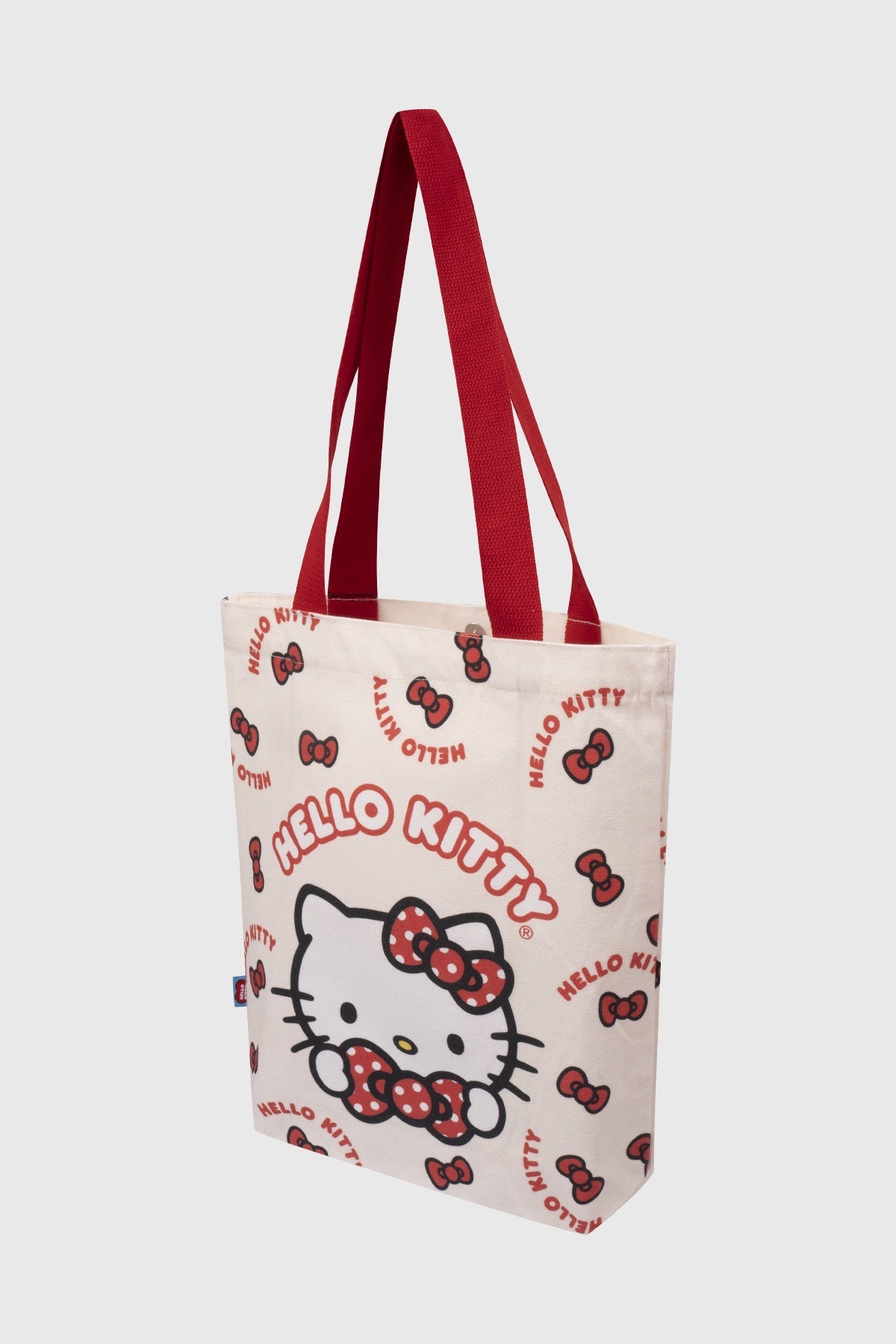 Bolsa de tela cruda con diseño de Hello Kitty en tonos rojos, presenta a la icónica gatita con moño, ideal para fans de Sanrio.