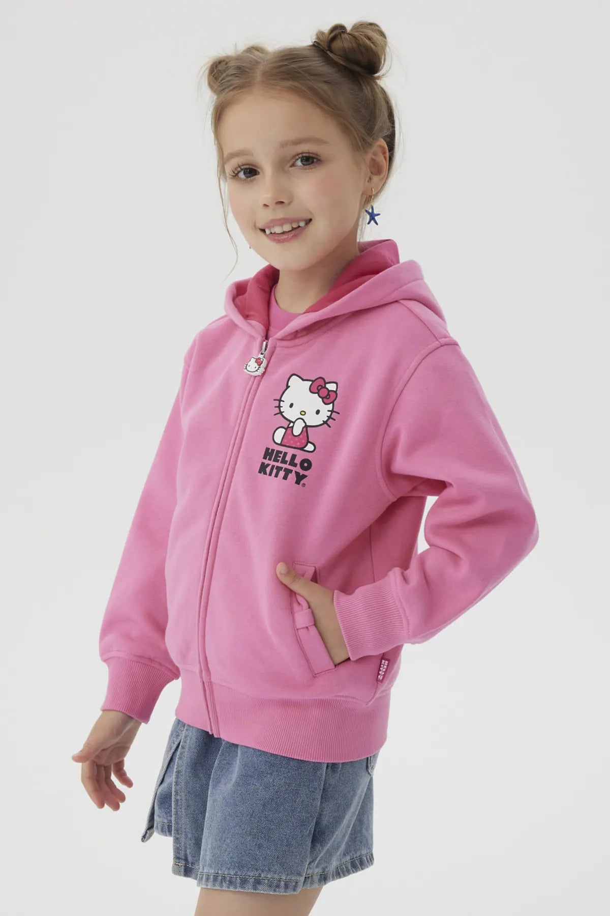 Polerón rosado de Hello Kitty con ilustración en el pecho de la icónica gata y su nombre en letras negras, ideal para fans de Sanrio.