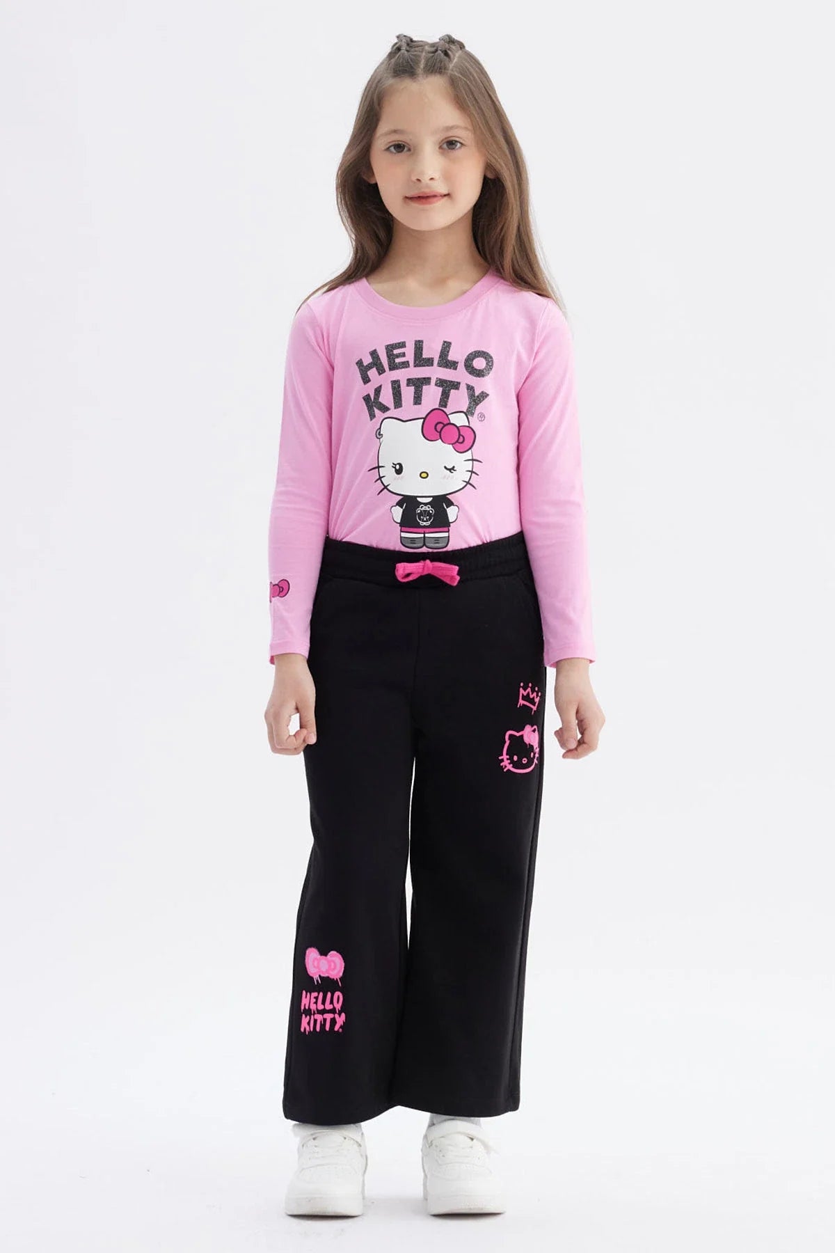 Pantalón buzo negro con detalles en rosa, presenta ilustraciones de Hello Kitty en estilo moderno, ideal para fans de la cultura pop y el kawaii.